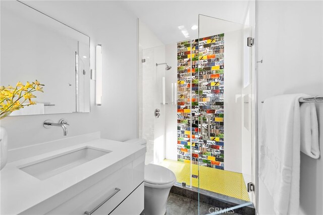 bathroom featuring toilet, a shower stall, and vanity