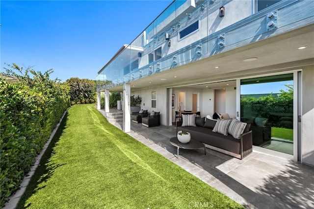 rear view of house featuring an outdoor living space, a yard, stucco siding, and a patio area