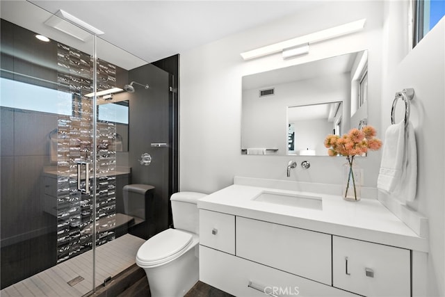 full bath featuring visible vents, vanity, toilet, and a shower stall