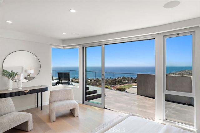 bedroom with recessed lighting, baseboards, a water view, and wood finished floors