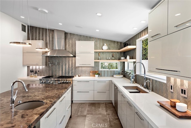 kitchen featuring a sink, modern cabinets, and wall chimney exhaust hood