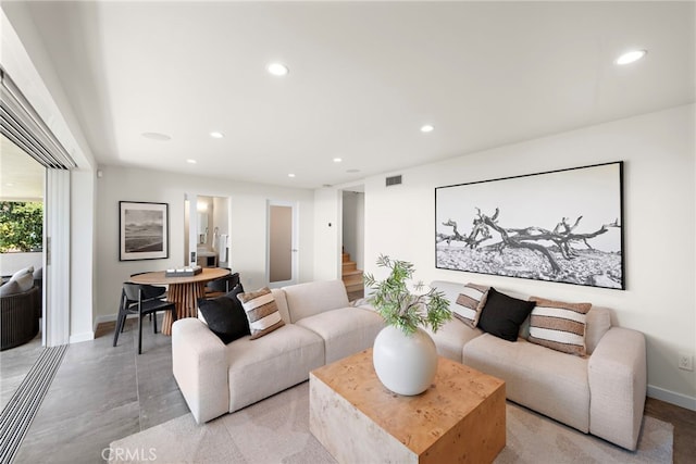 living room featuring recessed lighting, visible vents, baseboards, and stairs