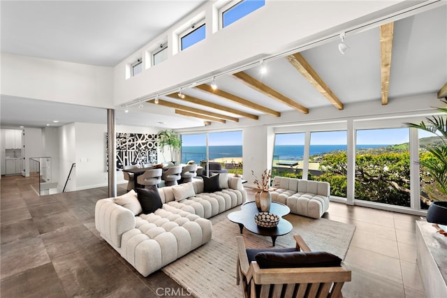 tiled living room featuring a wealth of natural light, beamed ceiling, and track lighting