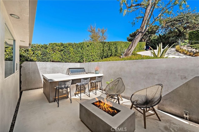 view of patio / terrace featuring a fire pit and outdoor dry bar