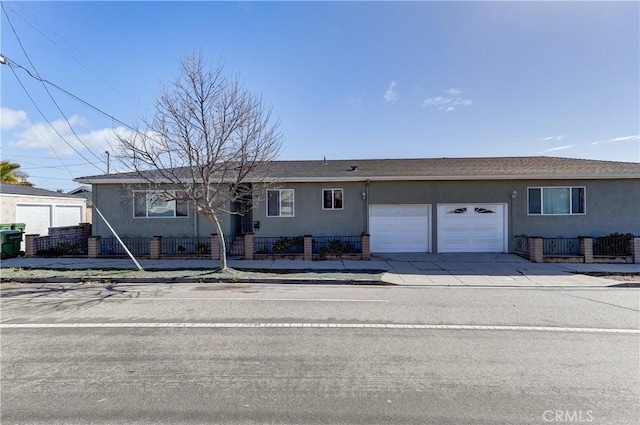 single story home with a fenced front yard, stucco siding, an attached garage, and concrete driveway