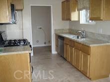 kitchen with stove, a sink, light countertops, and stainless steel dishwasher