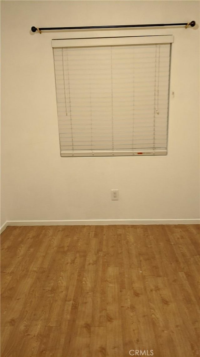 unfurnished room featuring light wood-style floors and baseboards