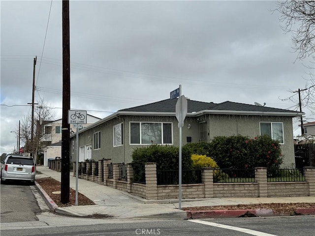 view of front of house with stucco siding and a fenced front yard