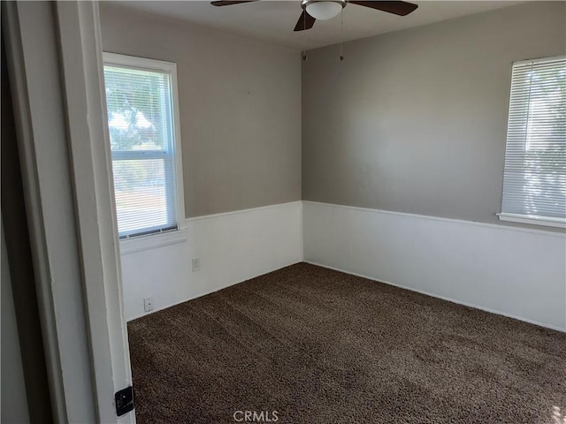 carpeted spare room featuring ceiling fan