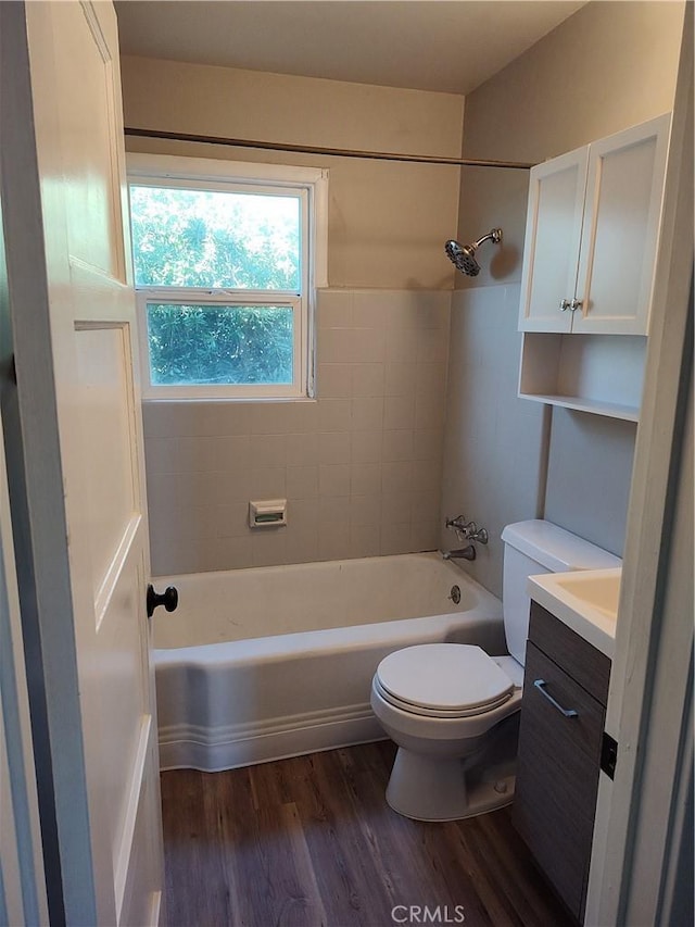 bathroom featuring toilet, bathing tub / shower combination, wood finished floors, and vanity