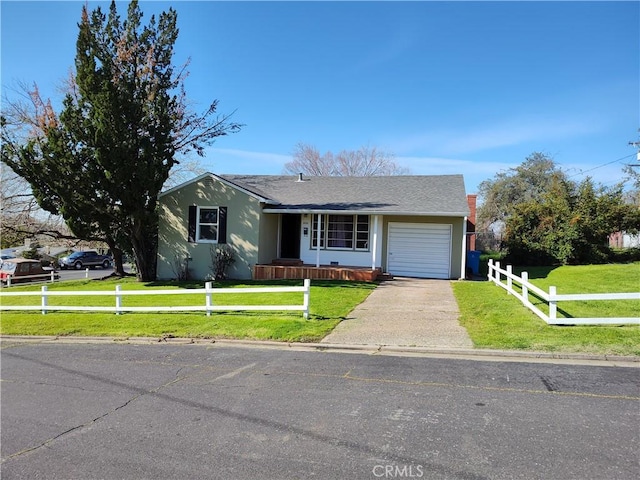 view of front of property featuring a fenced front yard, a front yard, driveway, and a garage