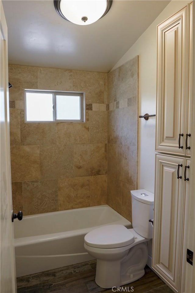 bathroom featuring toilet, wood finished floors, and shower / bath combination