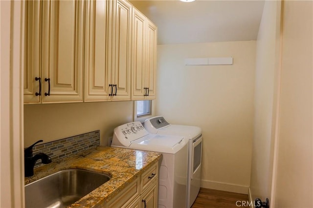 washroom featuring baseboards, dark wood finished floors, cabinet space, a sink, and independent washer and dryer