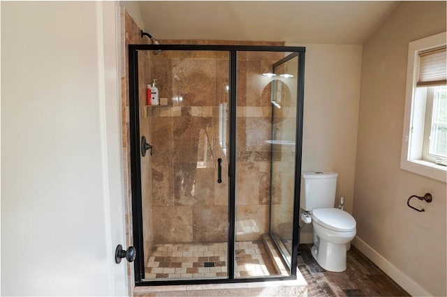 full bathroom featuring a shower stall, toilet, and baseboards