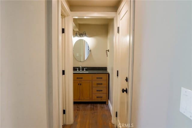 hallway with dark wood-type flooring and a sink