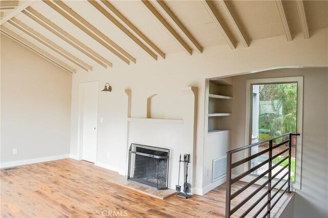 unfurnished living room featuring visible vents, baseboards, wood finished floors, and a fireplace