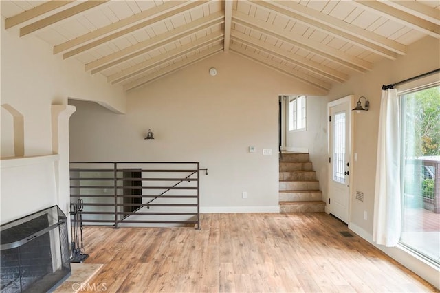 living area featuring lofted ceiling with beams, baseboards, light wood-type flooring, and wooden ceiling