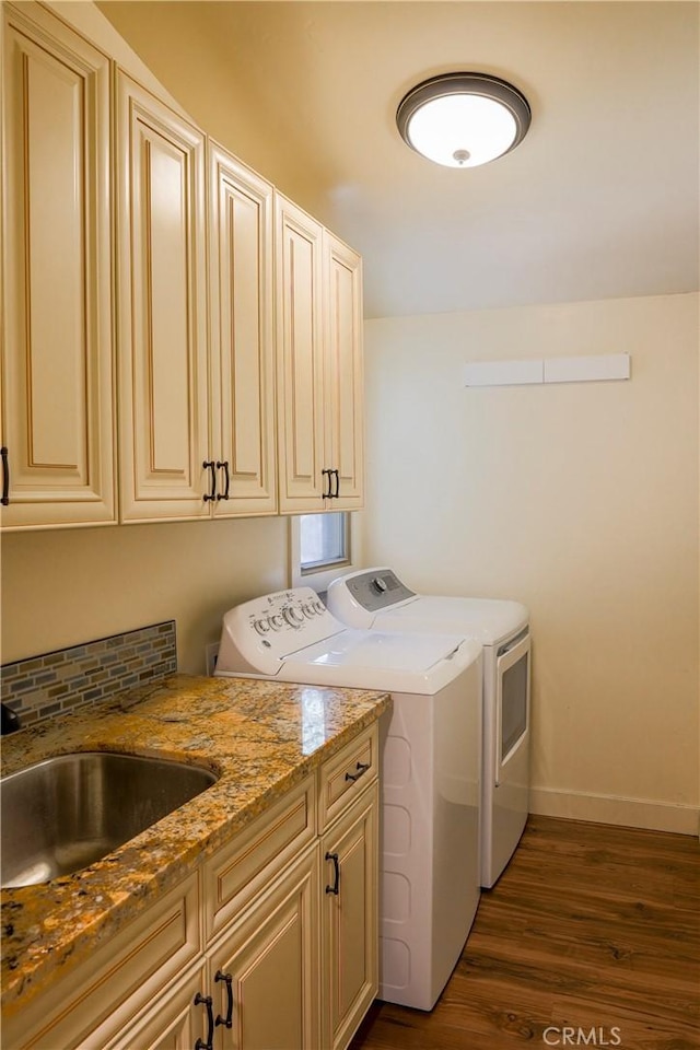 clothes washing area with baseboards, dark wood-style floors, cabinet space, independent washer and dryer, and a sink