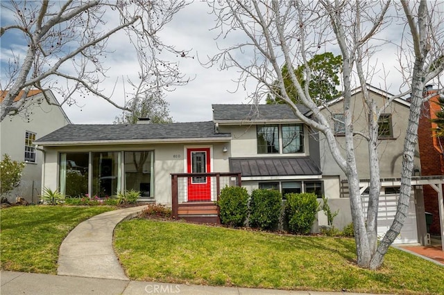 tri-level home with stucco siding, a front lawn, and roof with shingles