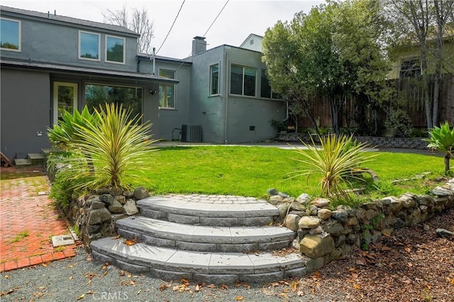 view of yard with central AC and fence