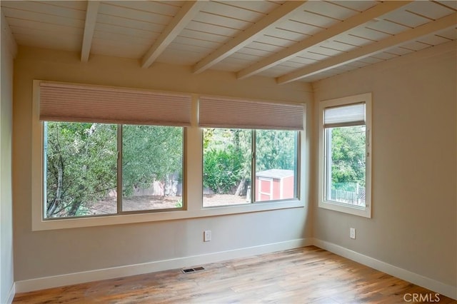 spare room with beamed ceiling, visible vents, wood finished floors, baseboards, and wood ceiling