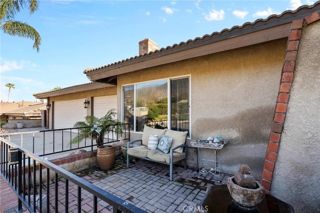 view of patio / terrace featuring a garage and a balcony