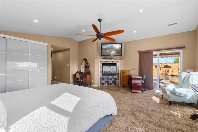 carpeted bedroom featuring lofted ceiling, a fireplace, recessed lighting, ceiling fan, and access to exterior