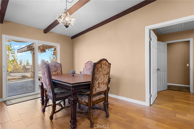 dining room featuring attic access, a notable chandelier, baseboards, and light wood-type flooring