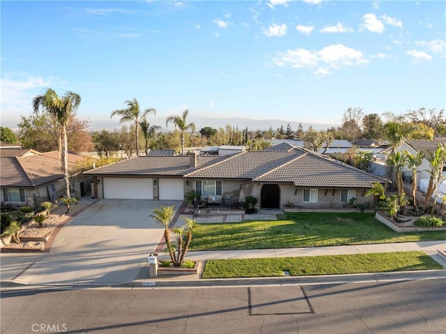 ranch-style home featuring a tiled roof, a front yard, stucco siding, driveway, and an attached garage