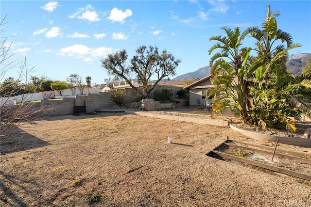 view of yard featuring a patio, fence, and a mountain view