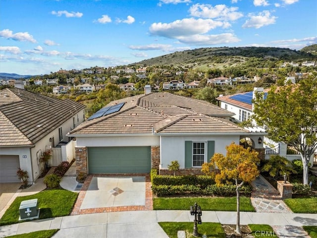 ranch-style home featuring a mountain view, a garage, brick siding, and driveway