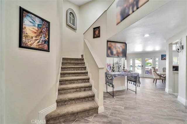 stairway featuring baseboards and french doors