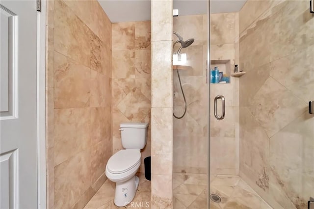 full bath with a stall shower, tile walls, and toilet