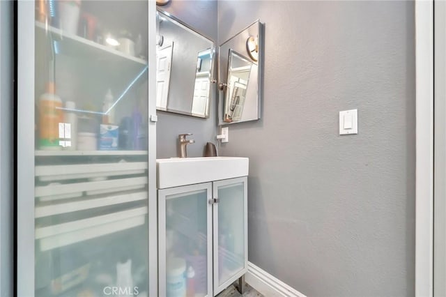 bathroom with a textured wall and vanity