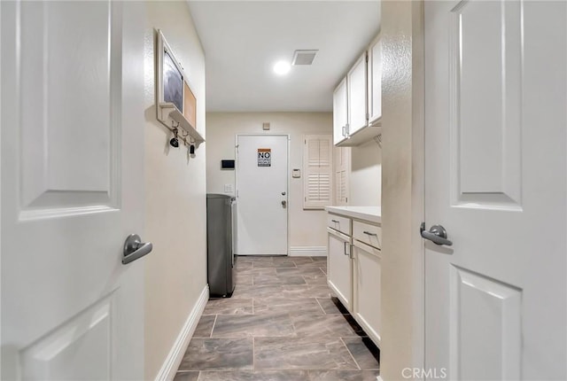 washroom with baseboards and visible vents