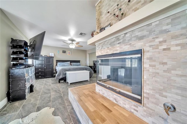 bedroom featuring baseboards, visible vents, ceiling fan, and a multi sided fireplace