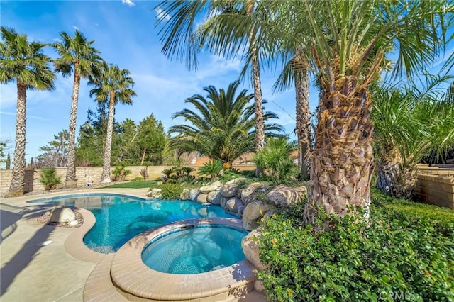 view of pool featuring a pool with connected hot tub and a fenced backyard