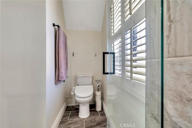 bathroom with baseboards and toilet