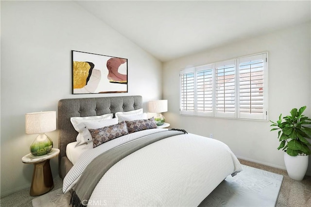 carpeted bedroom with vaulted ceiling and baseboards