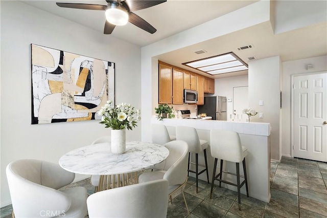 dining area featuring ceiling fan and visible vents