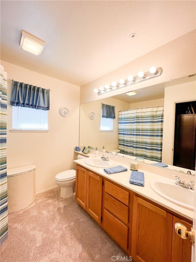 full bath featuring a shower with shower curtain, double vanity, toilet, and a sink