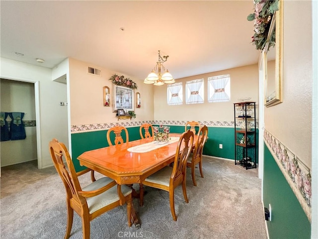 dining area with a notable chandelier, visible vents, baseboards, and carpet floors