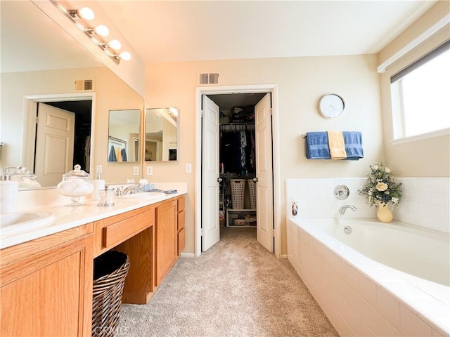 full bath featuring double vanity, visible vents, a bath, and a sink