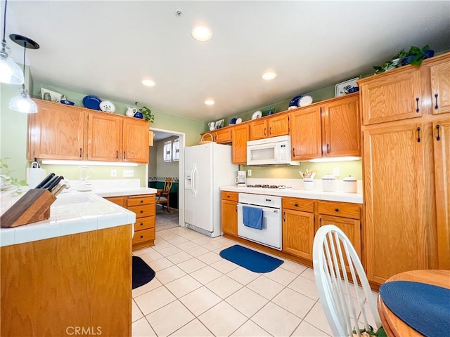 kitchen featuring white appliances, tile countertops, light tile patterned floors, recessed lighting, and decorative light fixtures