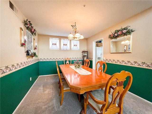 carpeted dining area with visible vents, baseboards, and an inviting chandelier