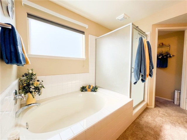 bathroom featuring a bath, visible vents, and a shower stall