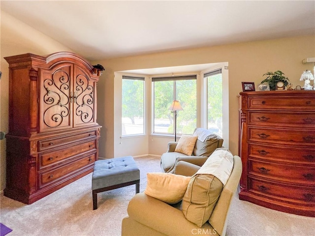 living area with vaulted ceiling and light colored carpet