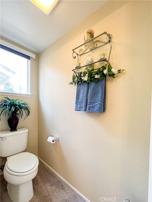 bathroom with baseboards and toilet