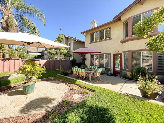 rear view of house with fence, an outdoor living space, a chimney, stucco siding, and a patio area