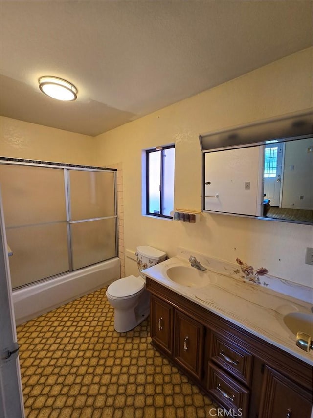 bathroom with tile patterned floors, a sink, toilet, and double vanity